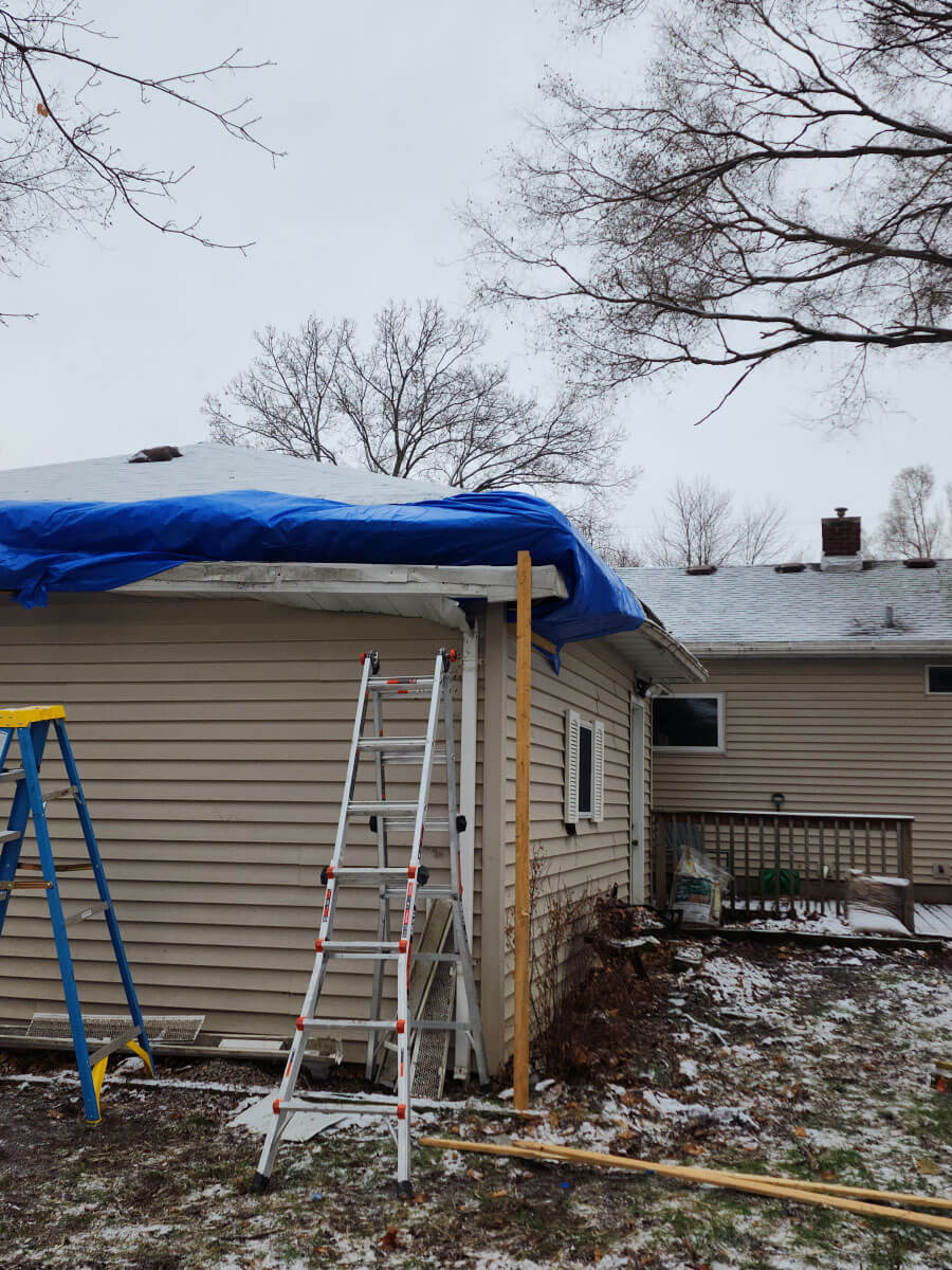 covering a roof with a tarmp as a temporary solution to a winter roof leak